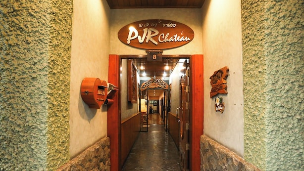 A hallway with a sign reading "PVR Chateau" and a number "8" above it. - Pjr Chateau (Bangkok)