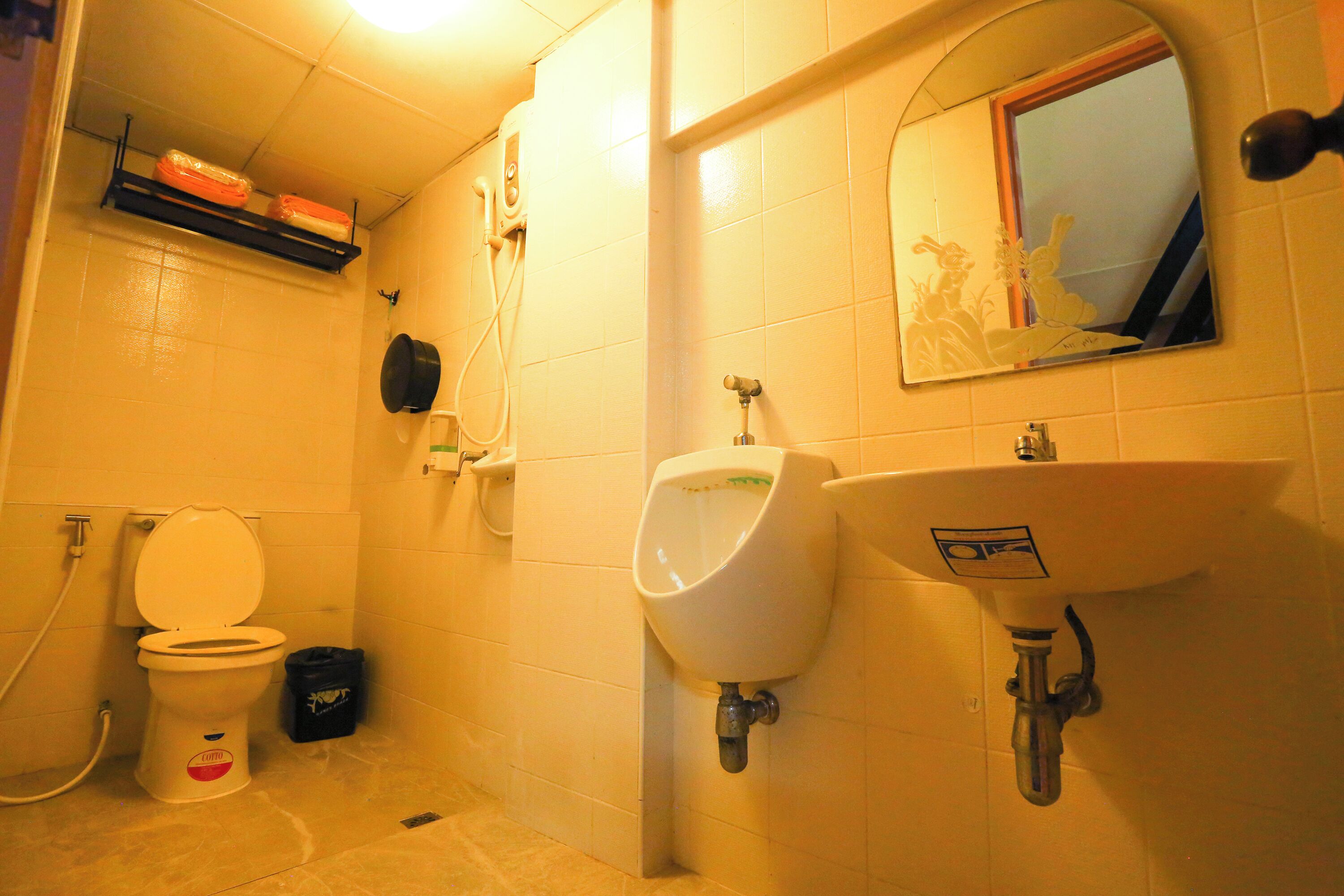 Des toilettes pour hommes comprenant des urinoirs, un lavabo et un miroir.