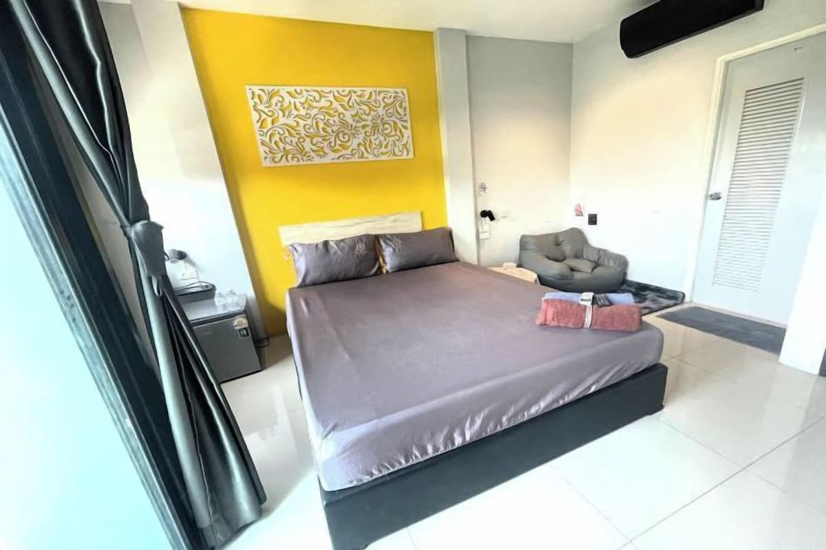 Une chambre moderne avec un grand lit, une chaise et un élément décoratif mural.