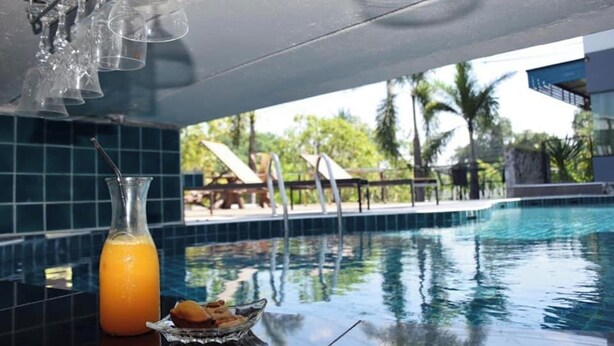 A poolside bar with a glass of orange juice and a bowl of snacks. - Bkl Pool Villa Pattaya (Bang Lamung)