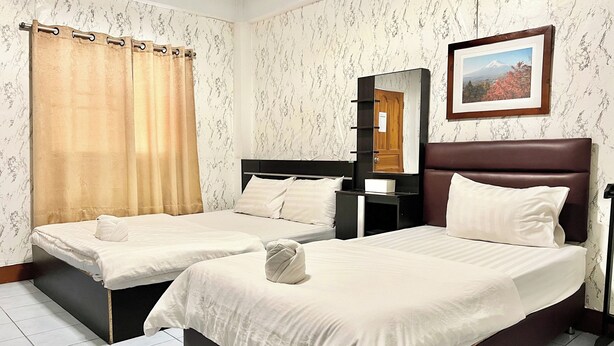 A hotel room with two beds, a mirror, a framed picture, and a curtain. - Jamjuree Place (Khon Kaen)