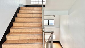 A staircase with wooden steps and metal railings, leading to an upper floor. - Jamjuree Place (Khon Kaen)