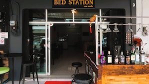 A bar area with a sign reading "BED STATION" and a variety of liquor bottles on the counter. - Bed Station Hostel Krabi (Krabi)