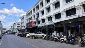 A street view with a row of parked motorcycles and a beige pickup truck. - Bed Station Hostel Krabi (Krabi)