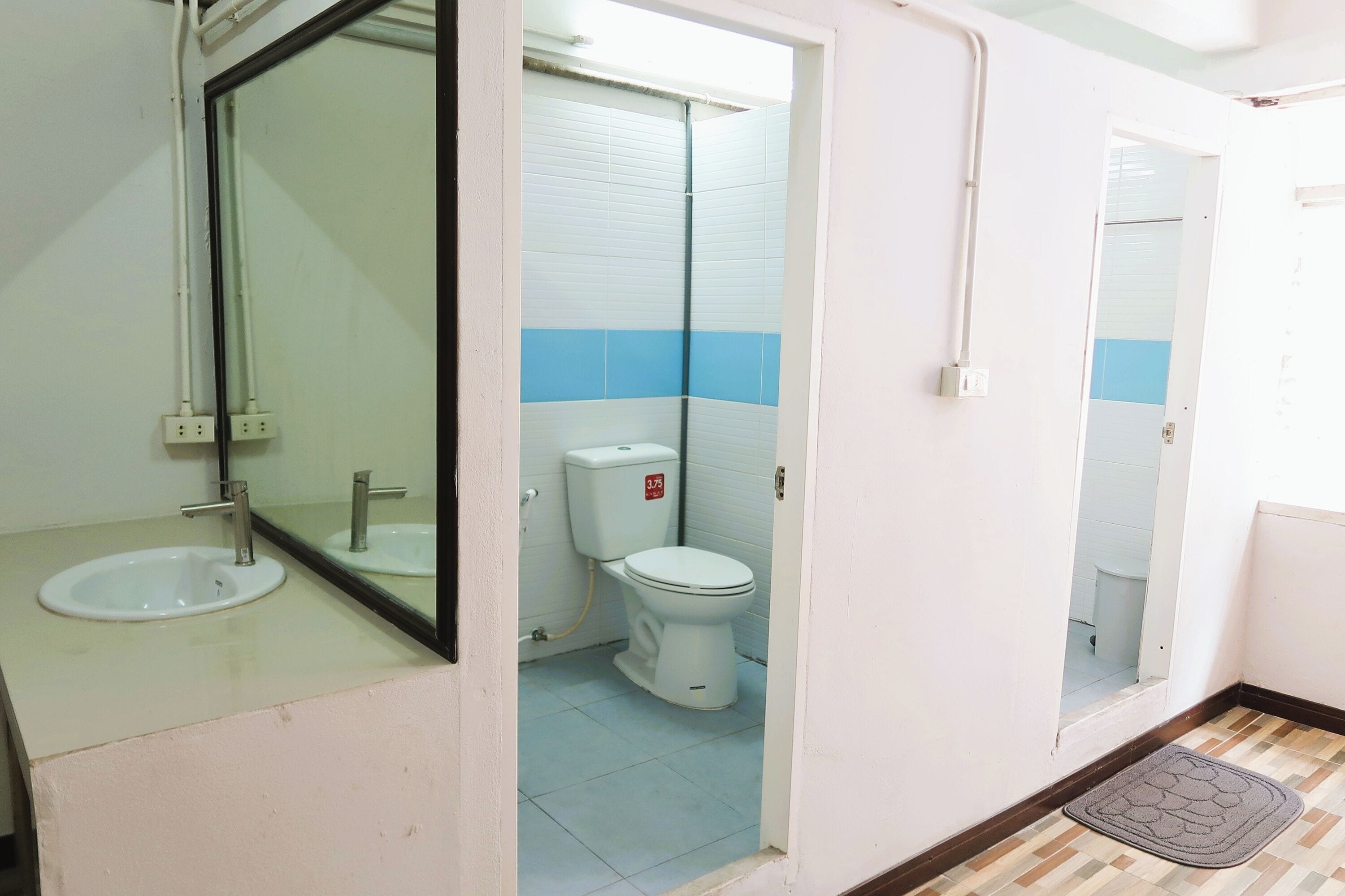 A bathroom with a sink, toilet, and mirror.