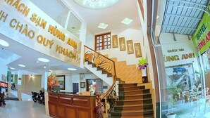 A hotel lobby with a reception desk, a staircase, and a large sign with hotel name. - Hung Anh Hotel (Ho Chi Minh City)