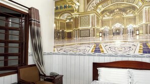 A hotel room with a large bed, a wooden nightstand, a chair, and a window with curtains. - Hung Anh Hotel (Ho Chi Minh City)