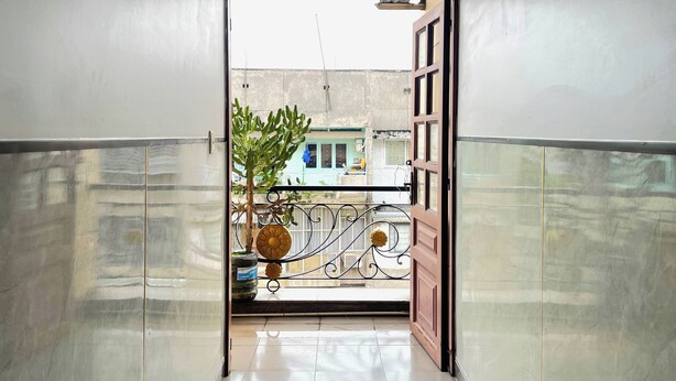 A hallway leading to a balcony with a potted plant and decorative elements. - Hung Anh Hotel (Ho Chi Minh City)