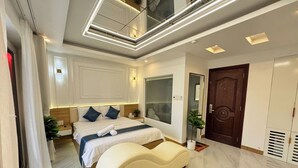 Un dormitorio moderno con una cama grande, un tocador, un espejo y un armario.
