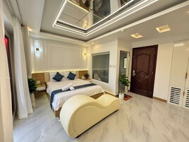 Quarto moderno com uma cama grande, penteadeira, espelho e guarda-roupa.