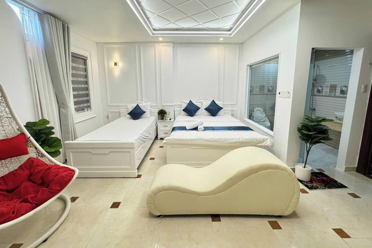 Una habitación de hotel moderna con una cama grande, un sofá y un pequeño rincón de descanso.