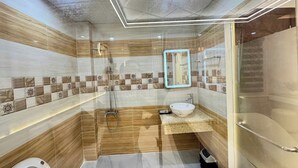 Un baño moderno con ducha envuelta en vidrio, tocador con lavabo y un inodoro.