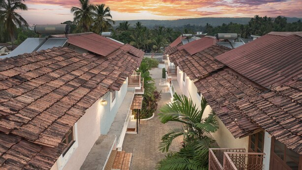 A row of traditional buildings with tiled roofs and a central pathway. - Echor Avontade Pool Villas Anjuna Goa (Anjuna)