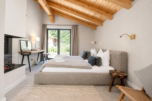 A bedroom with a large bed, a desk, a television, and a window with curtains. - Luxury Chalet in Niederau With Whirlpool (Hopfgarten im Brixental)