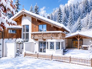 A wooden chalet with a balcony, large windows, and a snow-covered roof. - Luxury Chalet in Niederau With Whirlpool (Hopfgarten im Brixental)