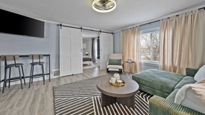 Un salon moderne avec un canapé, une table basse et un téléviseur.
