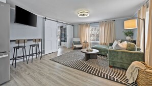 Un salon moderne avec un canapé, une table basse et un téléviseur fixé au mur.