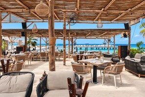 An outdoor seating area with wicker furniture and a view of the ocean.