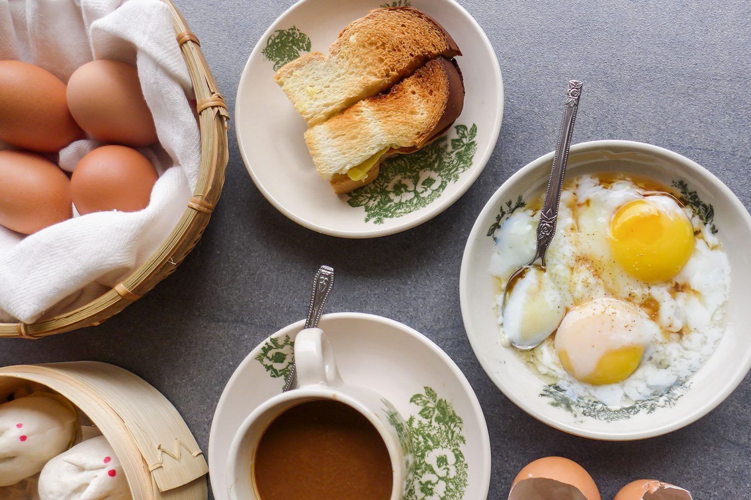 A breakfast setting with eggs, toast, and a cup of coffee on a table.