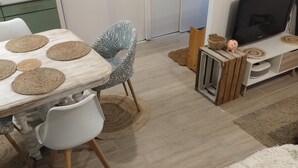Un comedor con una mesa de madera, sillas blancas y protectores de mesa tejidos.