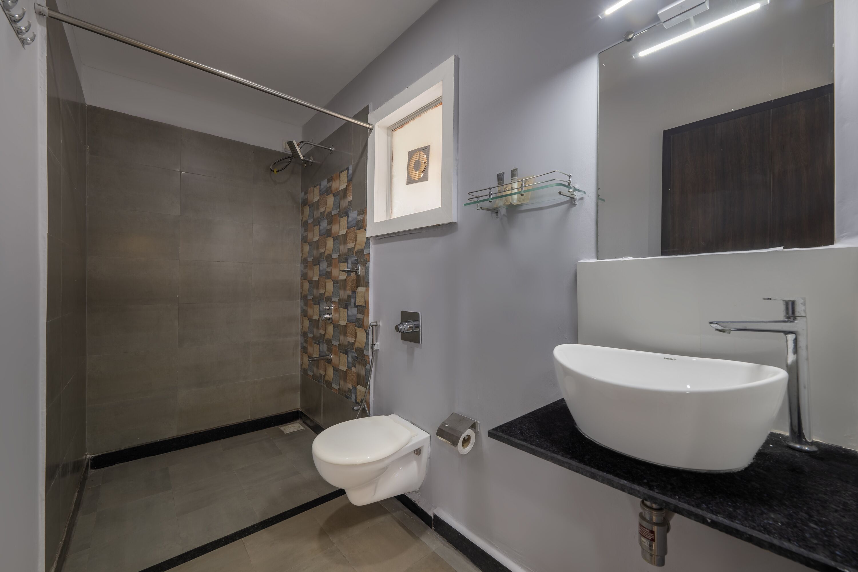 A modern bathroom with a shower, toilet, and sink.