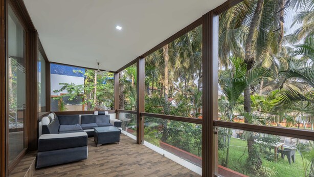 Un balcón amplio con ventanas grandes que dan a un jardín exuberante.