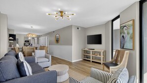 Una sala de estar con un sofá, una mesa de centro, un televisor y un cuadro en la pared.