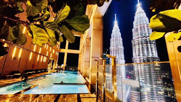 Zona de piscina con vista al Burj Khalifa de noche.