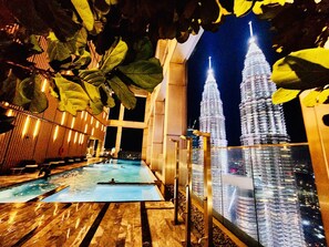 Ein Poolbereich mit Blick auf den Burj Khalifa bei Nacht.