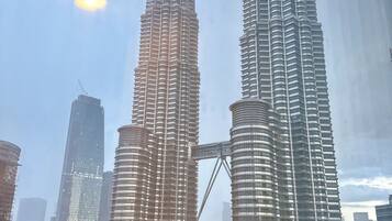 Two prominent skyscrapers with a clear sky and a sun visible in the background.