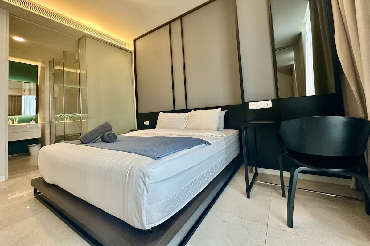 Una habitación de hotel moderna con una cama, un escritorio y una silla.