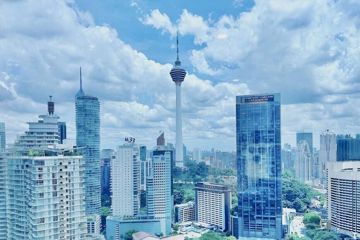 Un paisaje urbano con modernos rascacielos, incluyendo una torre destacada con un diseño único.