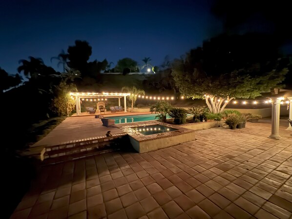 A patio area with a pool, outdoor seating, and string lights. - Riverside Retreat: Private Oasis w/ Pool, Hot Tub, Stunning Views! (Riverside)