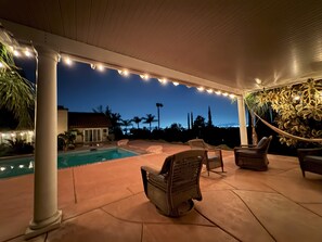 A covered outdoor area with a pool, wicker chairs, and string lights. - Riverside Retreat: Private Oasis w/ Pool, Hot Tub, Stunning Views! (Riverside)