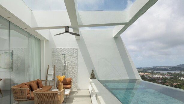 Eine moderne Dachterrasse mit Glasgeländer, einem Pool und Blick auf die Stadtlandschaft.