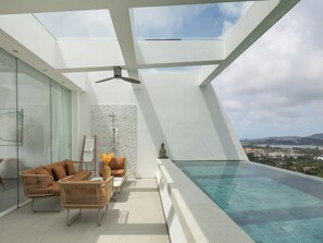 A modern rooftop terrace with a glass balustrade, a pool, and a view of the cityscape. - The Flourish Villa by Elite Havens (Koh Samui)