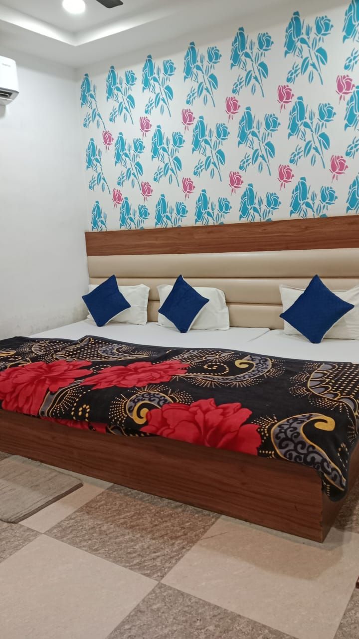 Een slaapkamer met een bed, een hoofdeinde en een bloemenpatroon op het wandontwerp.