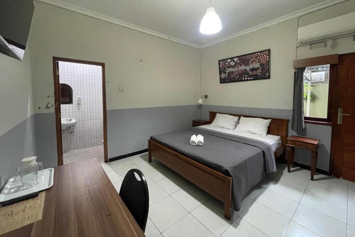 Une chambre à coucher comprenant un lit, une table de chevet et un bureau avec une chaise.
