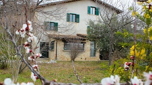 A stone building with green shutters, surrounded by trees and flowering branches. - House with pool in the open countryside - At Aunt Daniela's House, Oasis in Silence. (Polesio)