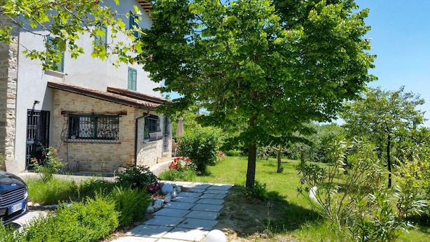 A stone building with a tiled roof, a paved pathway, and a garden with various plants and a tree. - House with pool in the open countryside - At Aunt Daniela's House, Oasis in Silence. (Polesio)