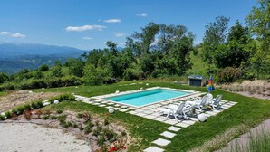 A rectangular swimming pool with a clear blue water, surrounded by a paved deck and white lounge chairs. - House with pool in the open countryside - At Aunt Daniela's House, Oasis in Silence. (Polesio)