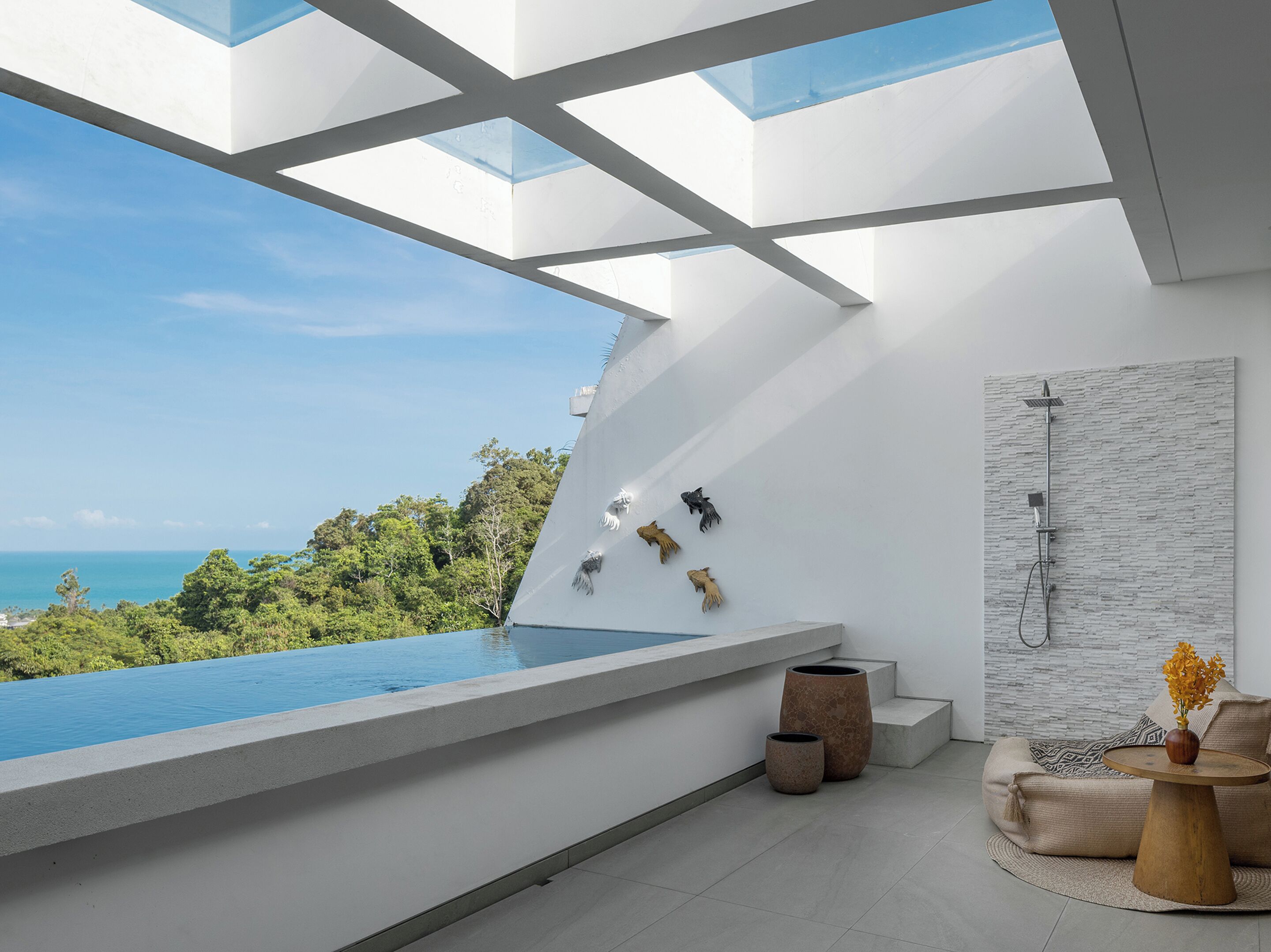 Een moderne badkamer met een groot dakvenster, een douche en uitzicht op de oceaan.