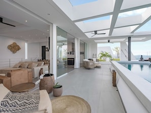 Ein modernes Interieur mit Pool, Sitzbereichen und Blick ins Freie.