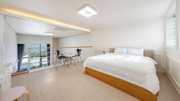 A hotel room with a large bed, a desk, and a chair, a balcony with a view, and a modern ceiling design.