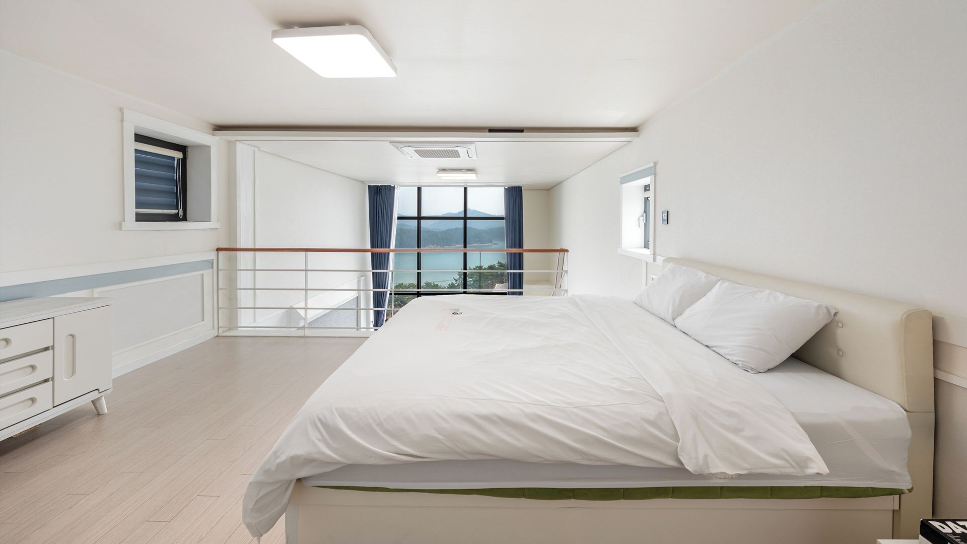 Ein Hotelzimmer mit Bett, Schreibtisch, Fenster mit Ausblick und Balkon.