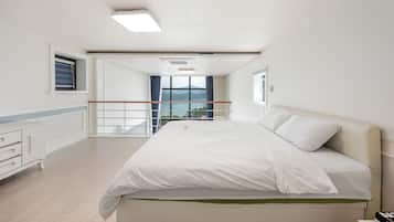 Ein Hotelzimmer mit Bett, Schreibtisch, Fenster mit Ausblick und Balkon.
