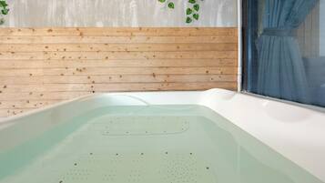 A hot tub with a wooden wall and a window.