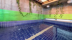 Una piscina interior con paredes y suelo de baldosas.