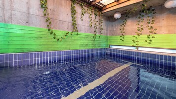 Una piscina interior con paredes y suelo de baldosas.