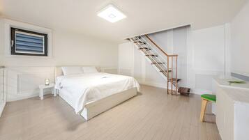 Un dormitorio con cama, mesita de noche, escritorio, silla, escalera y ventana con persianas.